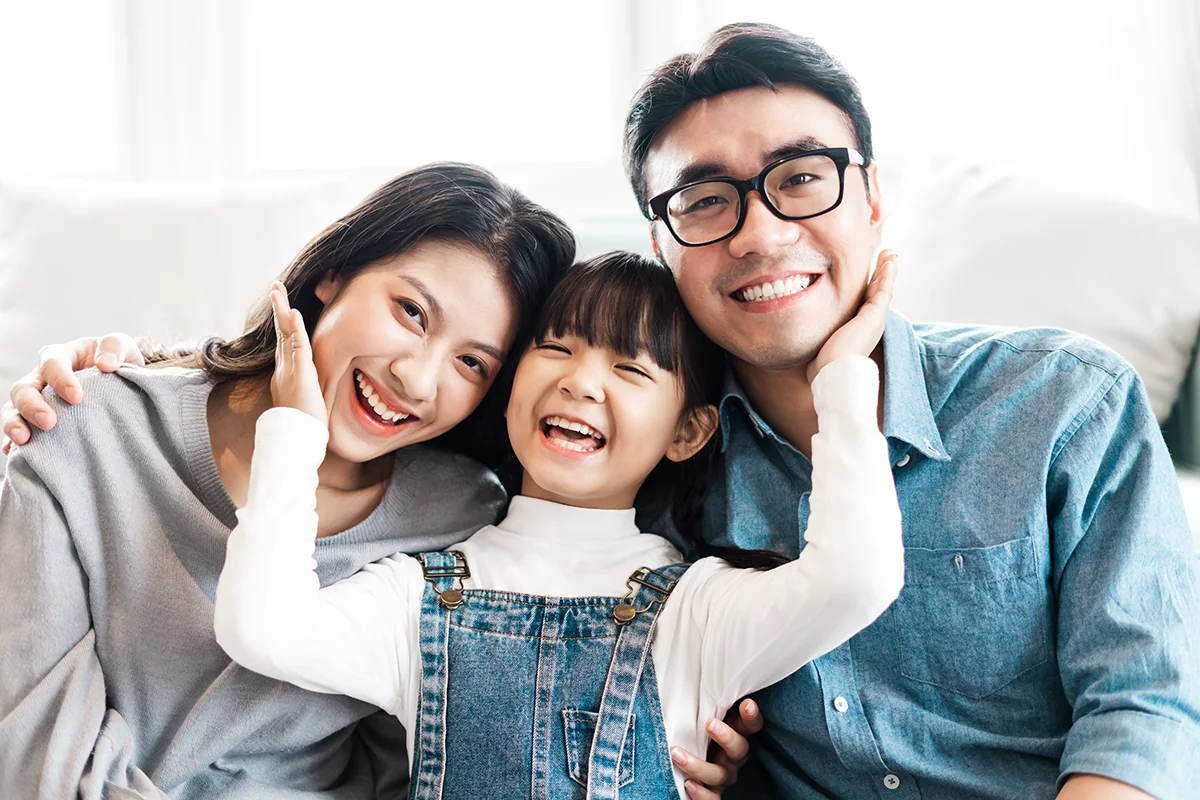 自宅で笑顔を見せる両親と子ども